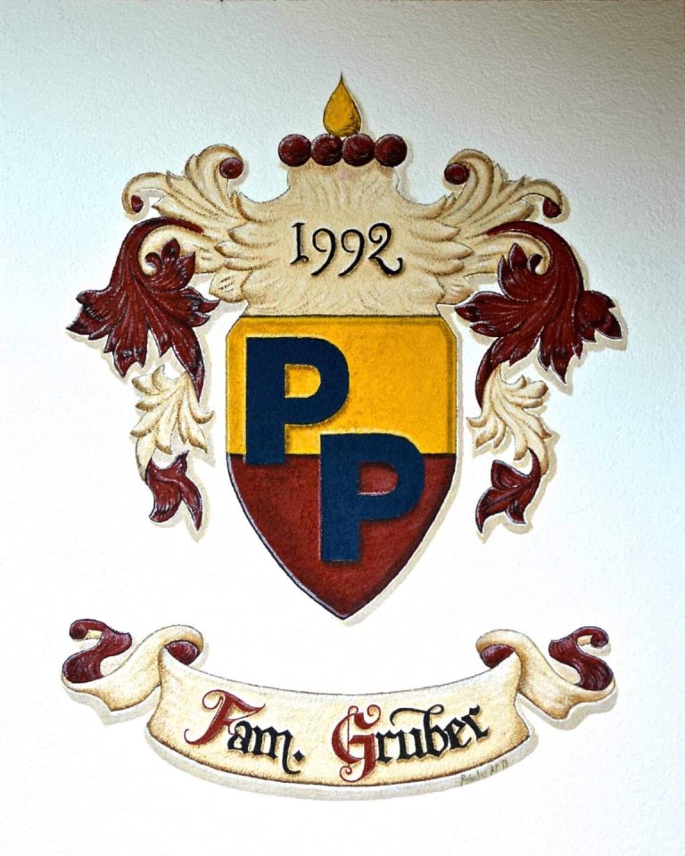 Familienwappen in warmen Farben, personalisiert mit "Fam. Gruber" und dem Jahr 1992.